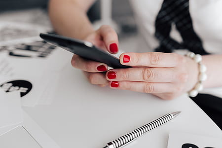 Businesswoman uses her mobile phone at her desk thumbnail