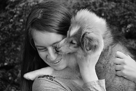 grayscale photo of woman hugging puppy thumbnail