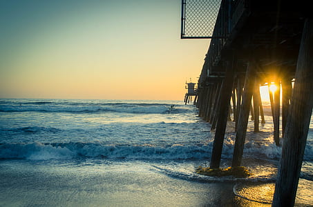 landscape photography of sea dock with sun rays thumbnail