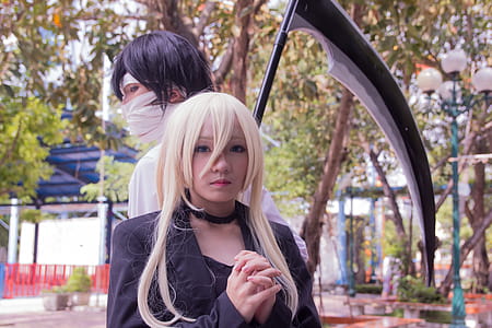 Male and Female Anime Character Cosplay With Scythe Beside Tree thumbnail