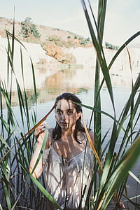 woman in body of water near grass thumbnail