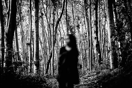selective focus photography of woman standing in middle of forest thumbnail