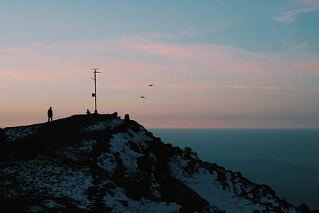 silhouette photo of person walking on mountain thumbnail
