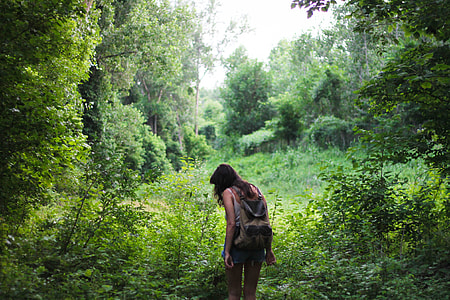 woman with brown and black backpack surrounded by trees at the jungle thumbnail