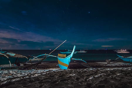 blue boat docked on seashore under nighttime thumbnail