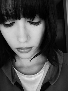 grayscale photo of woman wearing hoodie looking down thumbnail