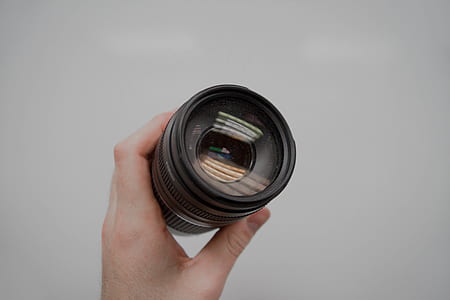 person holding black DSLR camera lens thumbnail