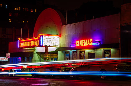 time-lapse photography of passing vehicles in front of New Gardens Cinemas building thumbnail