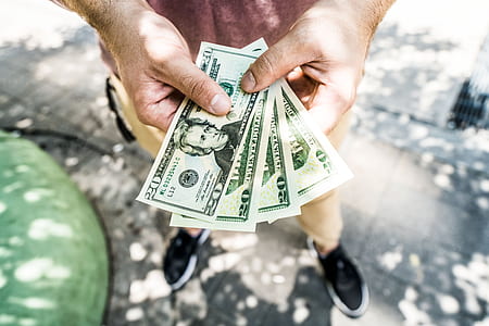 person holding US dollar banknotes thumbnail