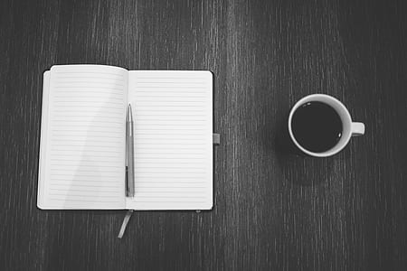 gray twist pen on notebook beside coffee filled mug thumbnail