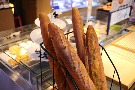 four baguettes on black metal rack thumbnail