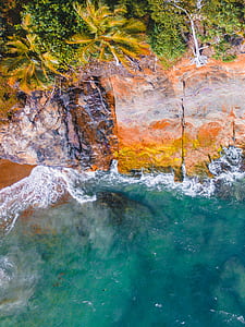 aerial photography of sea waves beside cliff during daytime thumbnail