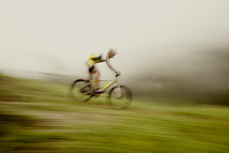 man riding yellow bicycle on green grass thumbnail
