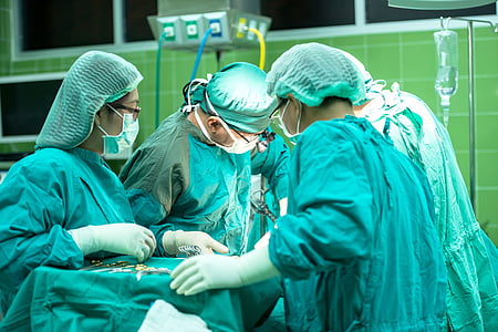 four medical staff with wearing medical gowns while doing surgery thumbnail