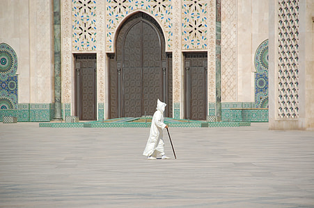 person in white coverall walking near mosque thumbnail