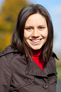 close-up photo of woman smiling while wearing black and red top thumbnail