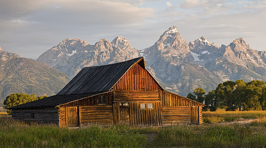 brown wooden house in the middle of field during daytime thumbnail