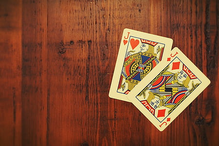 Jack of heart and diamond playing cards on brown surface thumbnail