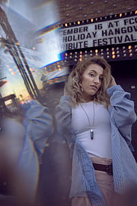 woman holding her hair front of store during daytime thumbnail