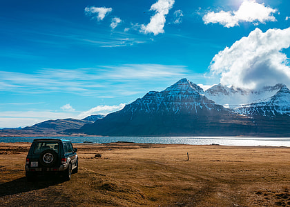 green off-road SUV on brown sand thumbnail