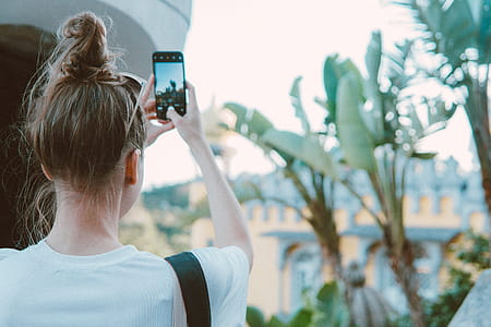Photo of a Woman Taking Picture of Banana Trees thumbnail