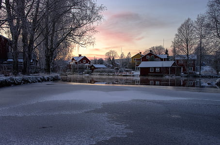 frozen lake near house thumbnail
