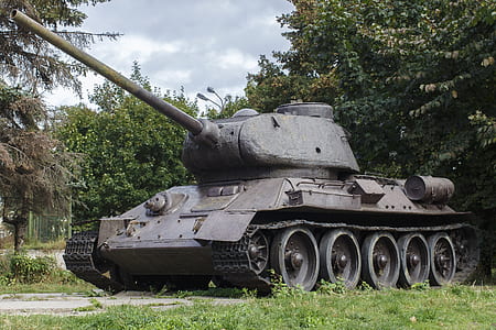 gray war tank near green leafed trees thumbnail