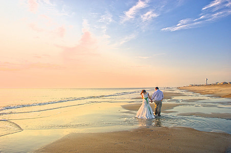 couple holding hands on shore near sea thumbnail