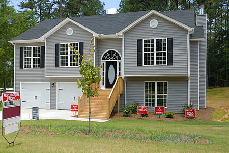 gray and white wooden house surrounded with trees thumbnail