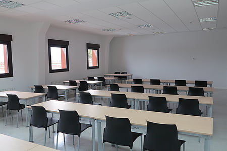 black plastic chairs near wooden desks thumbnail