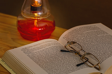 eyeglasses on a book near on fragrance bottle thumbnail