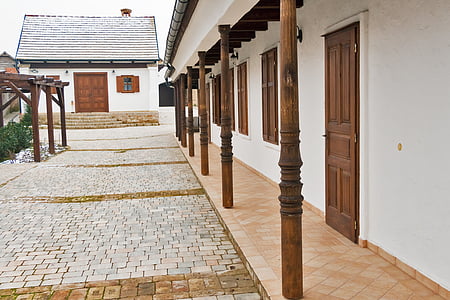 closed brown wooden doors of white concrete buildings at daytime thumbnail