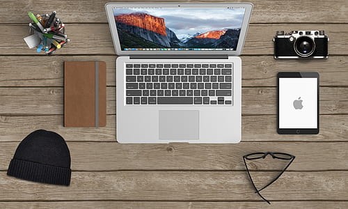 MacBook Air beside brown tablet computer case thumbnail