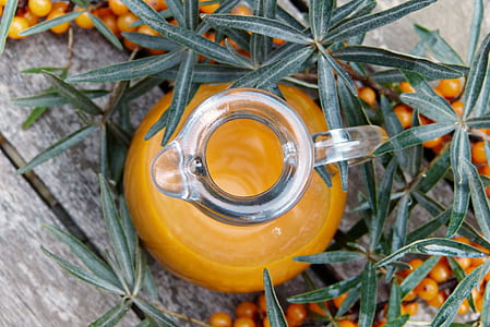 clear glass pitcher near small round fruit thumbnail