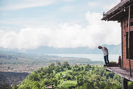 A young Caucasian man standing on the edge the balcony of an under-constructed house thumbnail