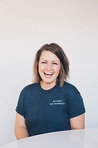 woman smiling sitting beside white table thumbnail