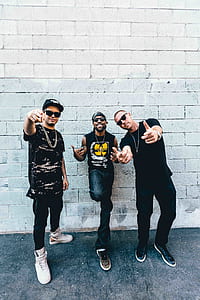 photo of three man standing beside wall thumbnail