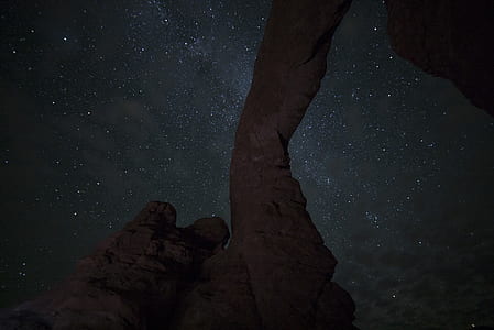 photo of brown rock formation under white stars at nighttime thumbnail