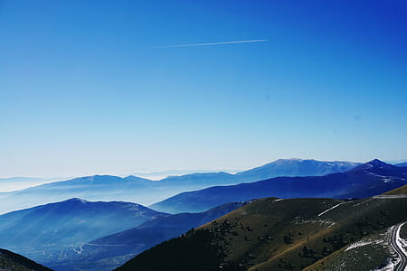 Green and Blue Fog Covered Mountains Under Blue Sky thumbnail