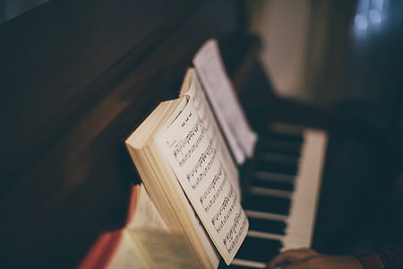 focus photography of music book placed on piano thumbnail