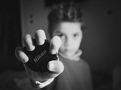 Selective Focus Photography of Boy Holding Nikon Lens Cover thumbnail