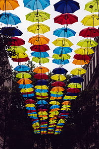 umbrellas hanging near brown buildings thumbnail