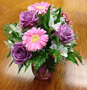 purple and pink petaled flower arrangement on brown wooden surface thumbnail