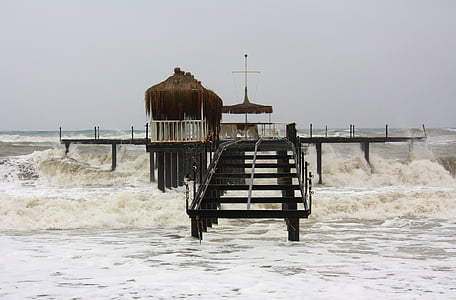 brown sea dock splashed by waves landscape photography thumbnail