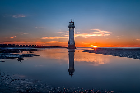 light house under blue sky at golden hour thumbnail