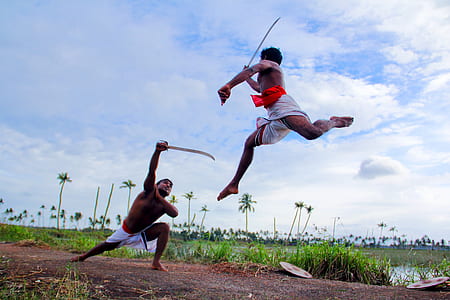 two person fencing swords during daytime thumbnail