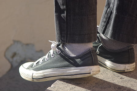 close-up photo of person wearing pair of gray-and-white low-top sneakers thumbnail