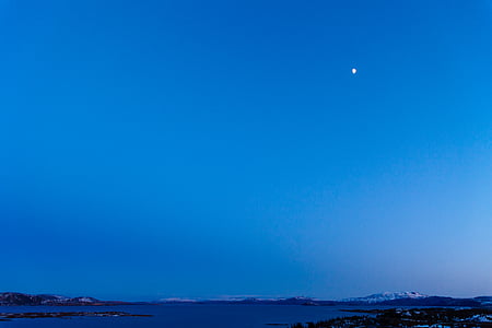 calm sea beside snow capped mountain during daytime thumbnail