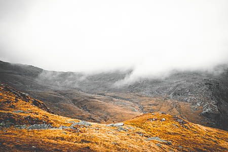 brown and gray mountain under white fogs during daytime photo thumbnail