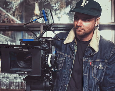man standing near black camera thumbnail